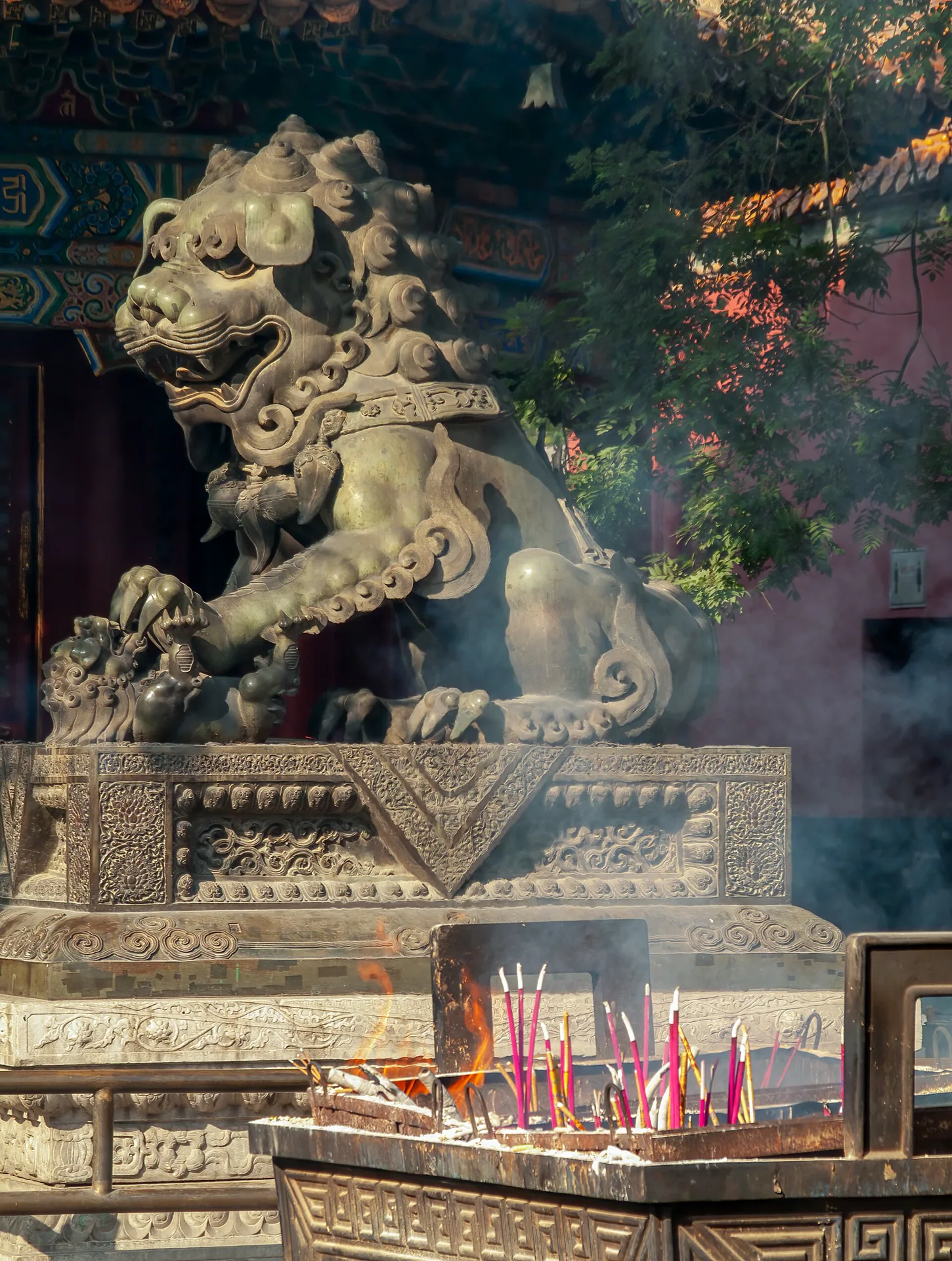 Carved guardian lion and incense haze at Yonghe Temple