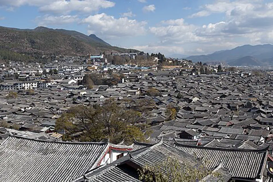 Tiled roofs of Lijiang Old Town spreading beneath Yunnan mountains