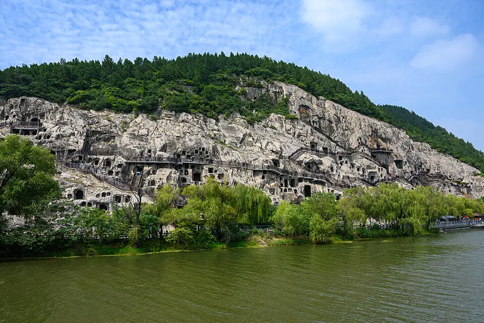 Longmen Grottoes carved across limestone cliffs beside the Yi River in Luoyang