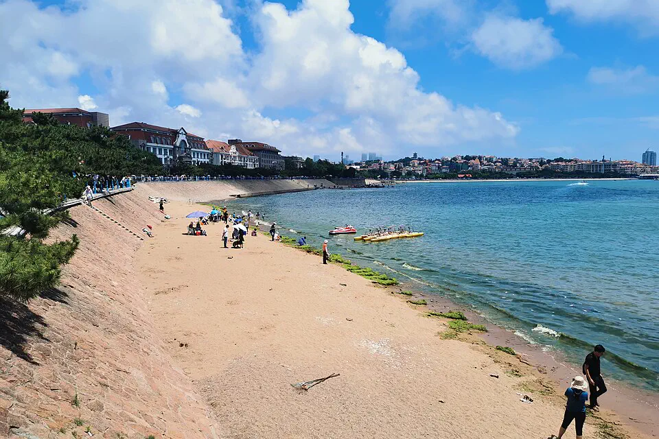 Qingdao waterfront, sandy beach and red-roofed historic city seen across the bay