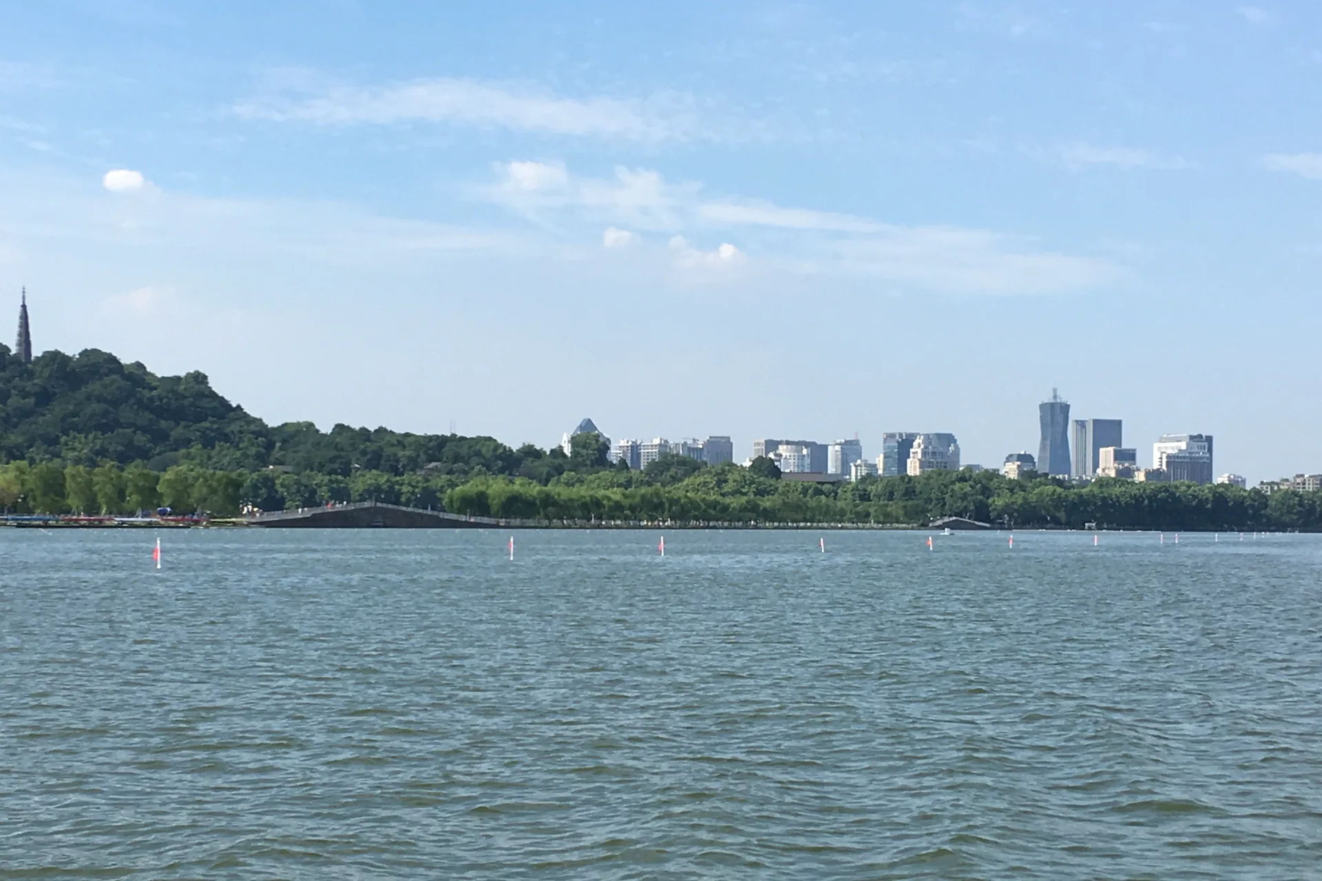 West Lake, wooded hills and the Hangzhou skyline beneath a clear sky
