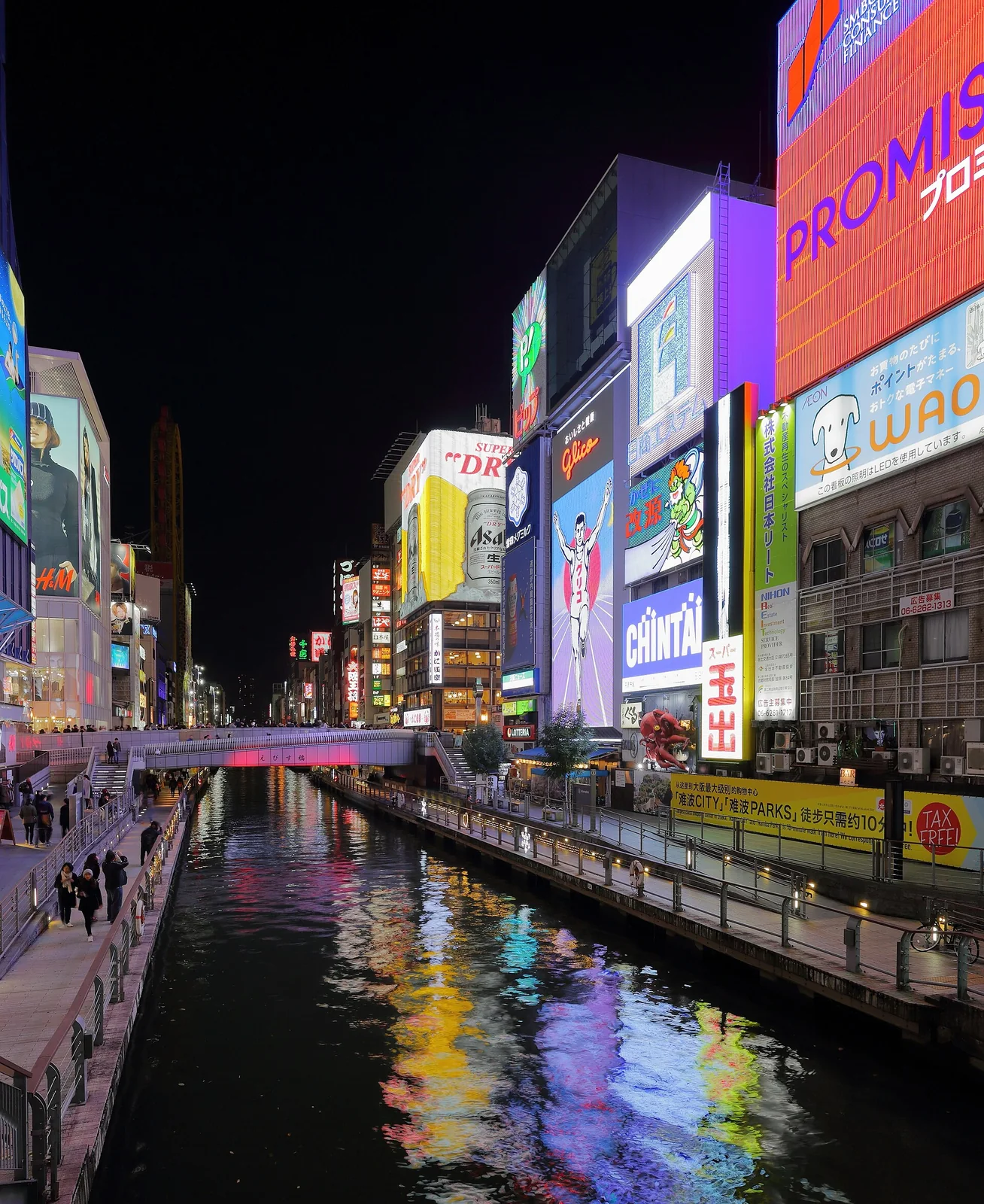 Neon signs and reflections along Osaka's Dotonbori canal at night