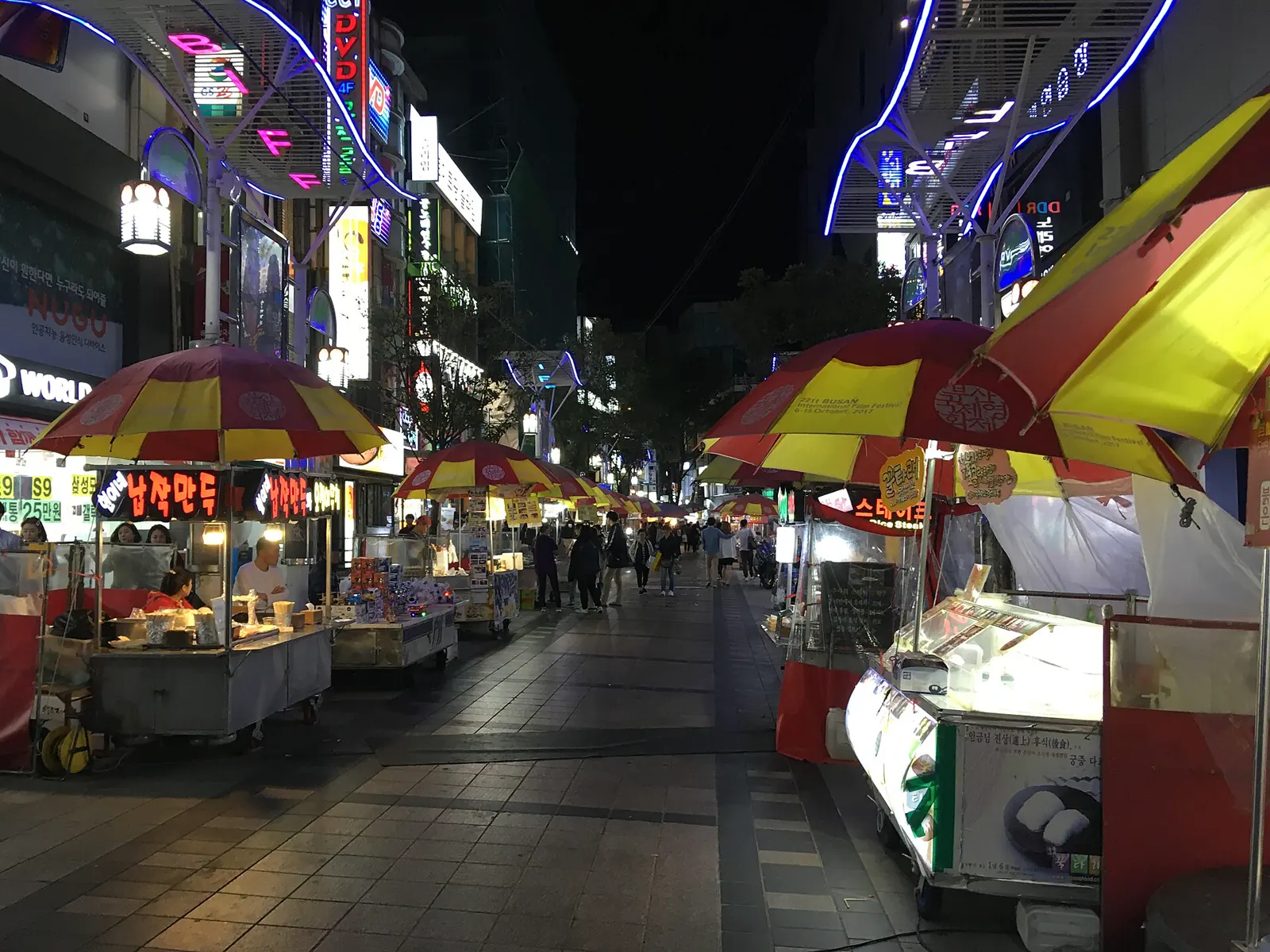 Food stalls and illuminated signs at BIFF Square at night