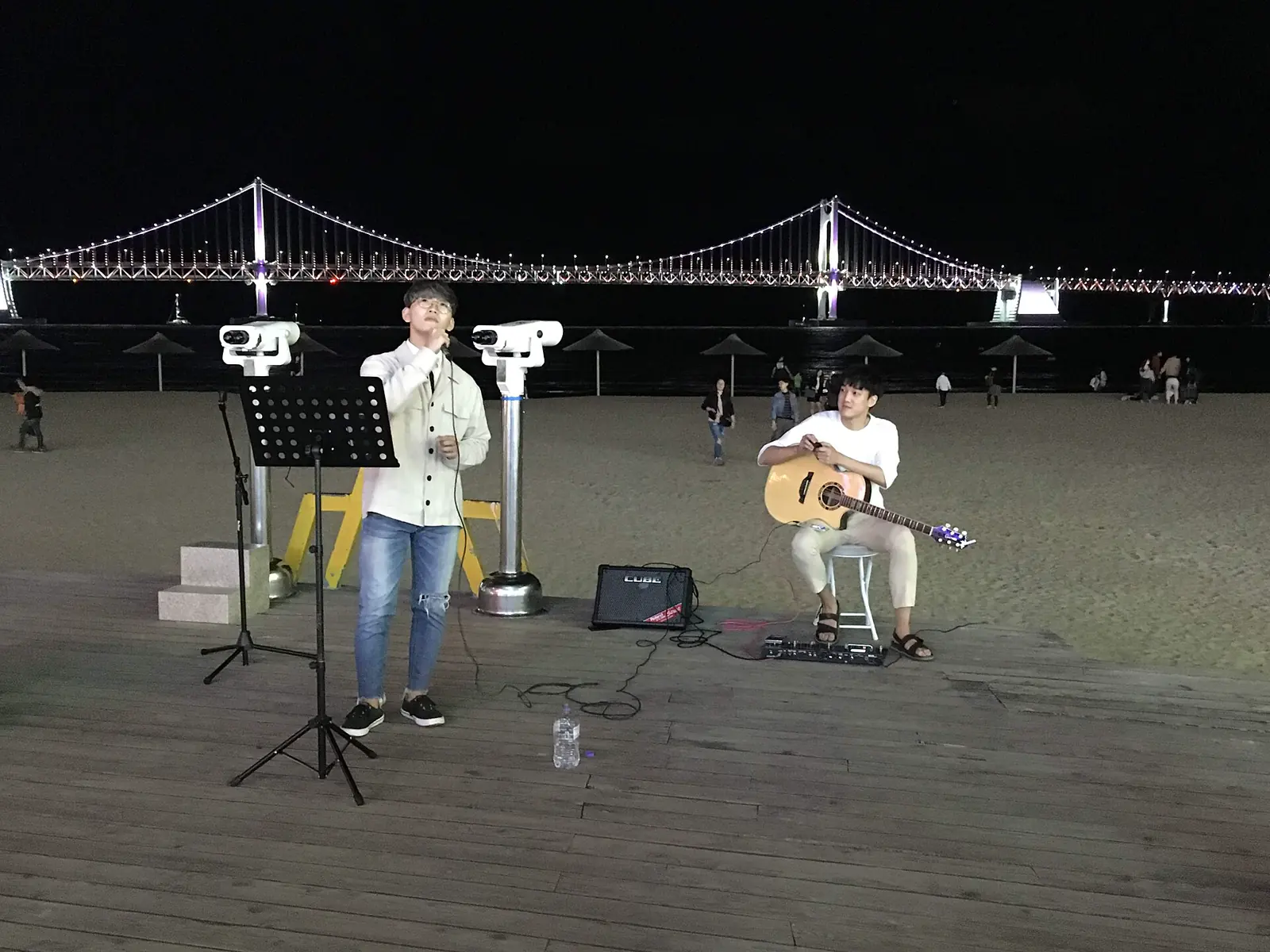 Musicians performing on the Gwangalli waterfront with Gwangan Bridge behind them