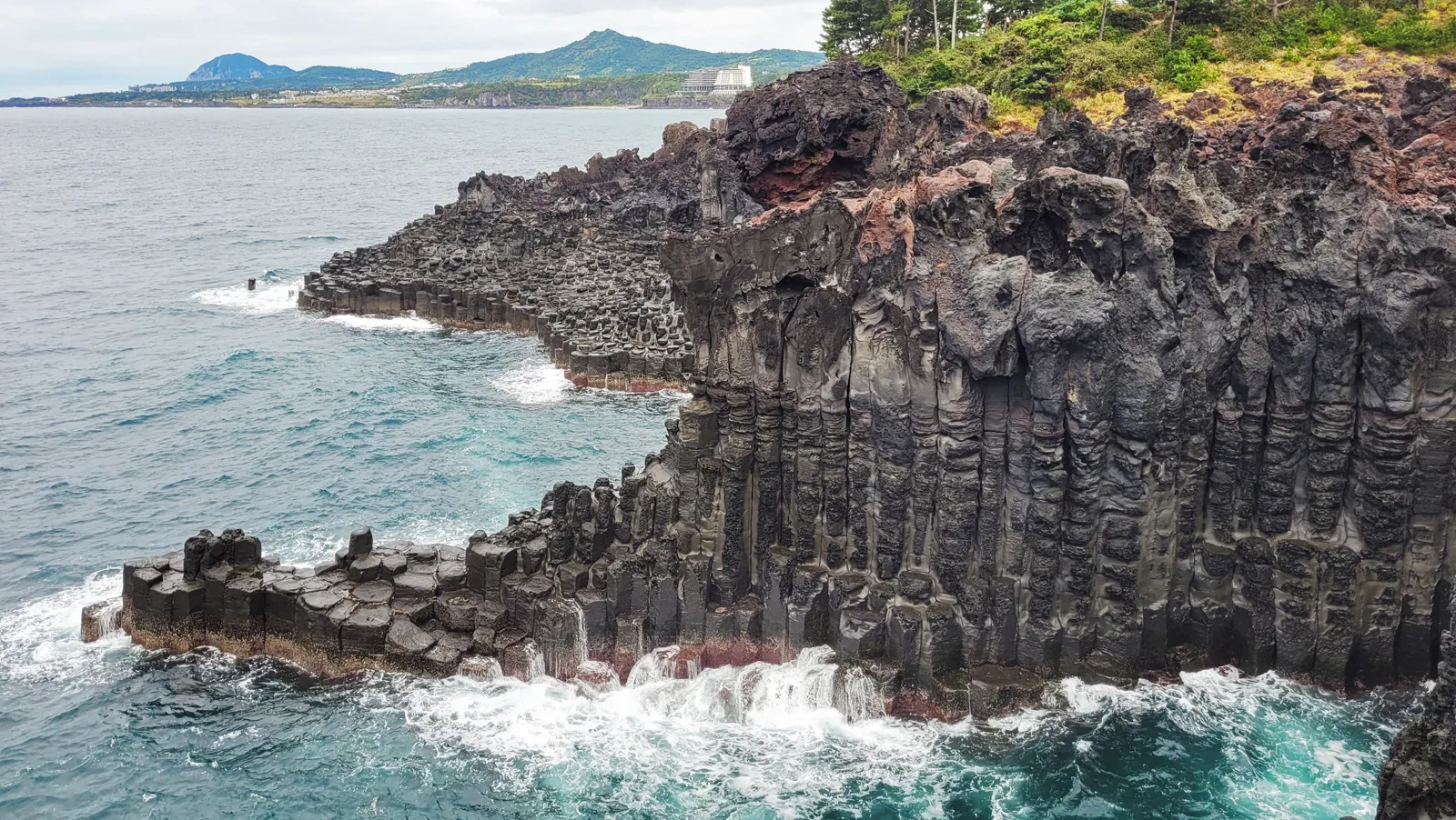 Hexagonal basalt columns meeting the sea at Daepo Jusangjeolli