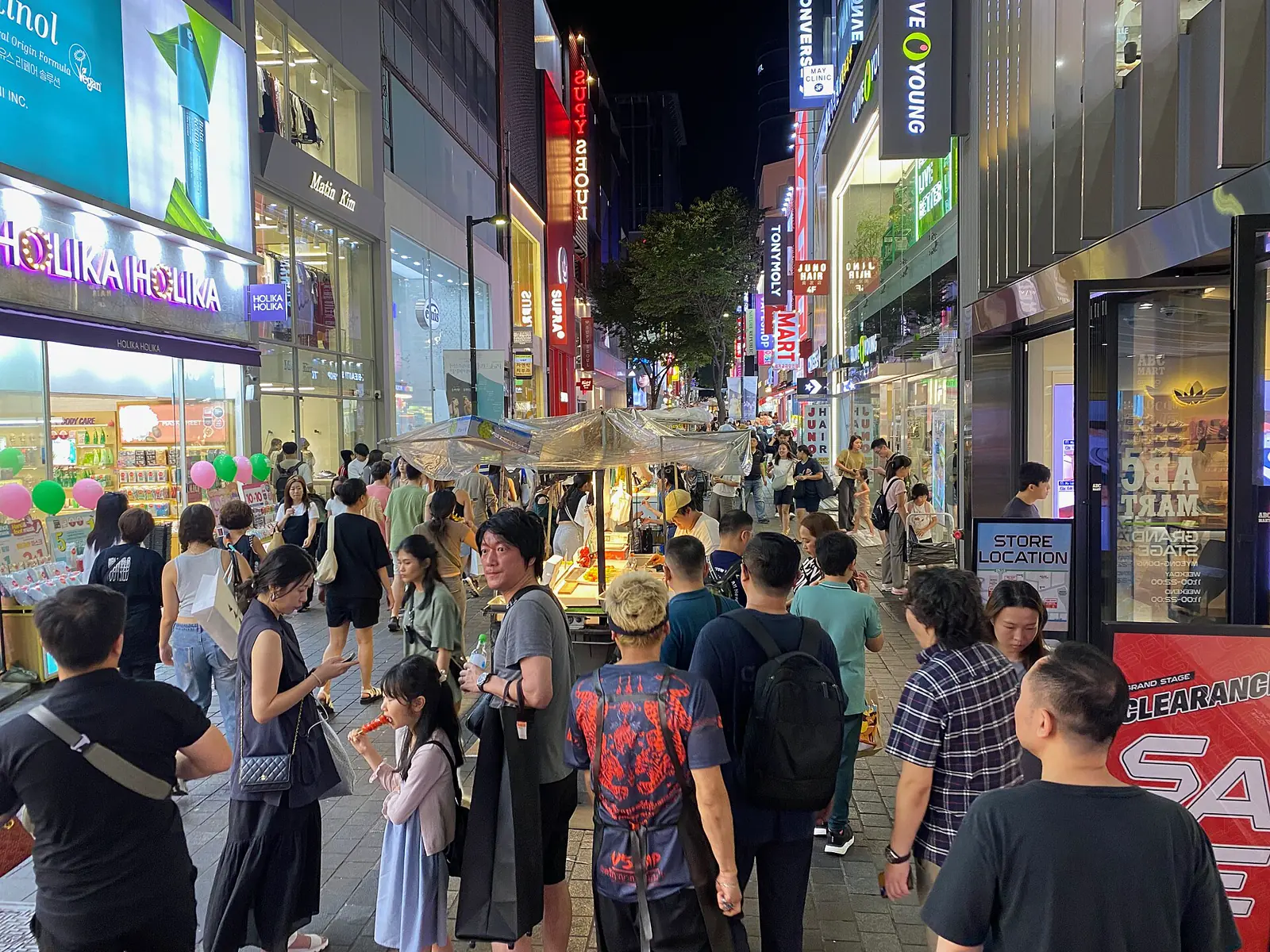 Neon signs and visitors along Myeongdong's night market street