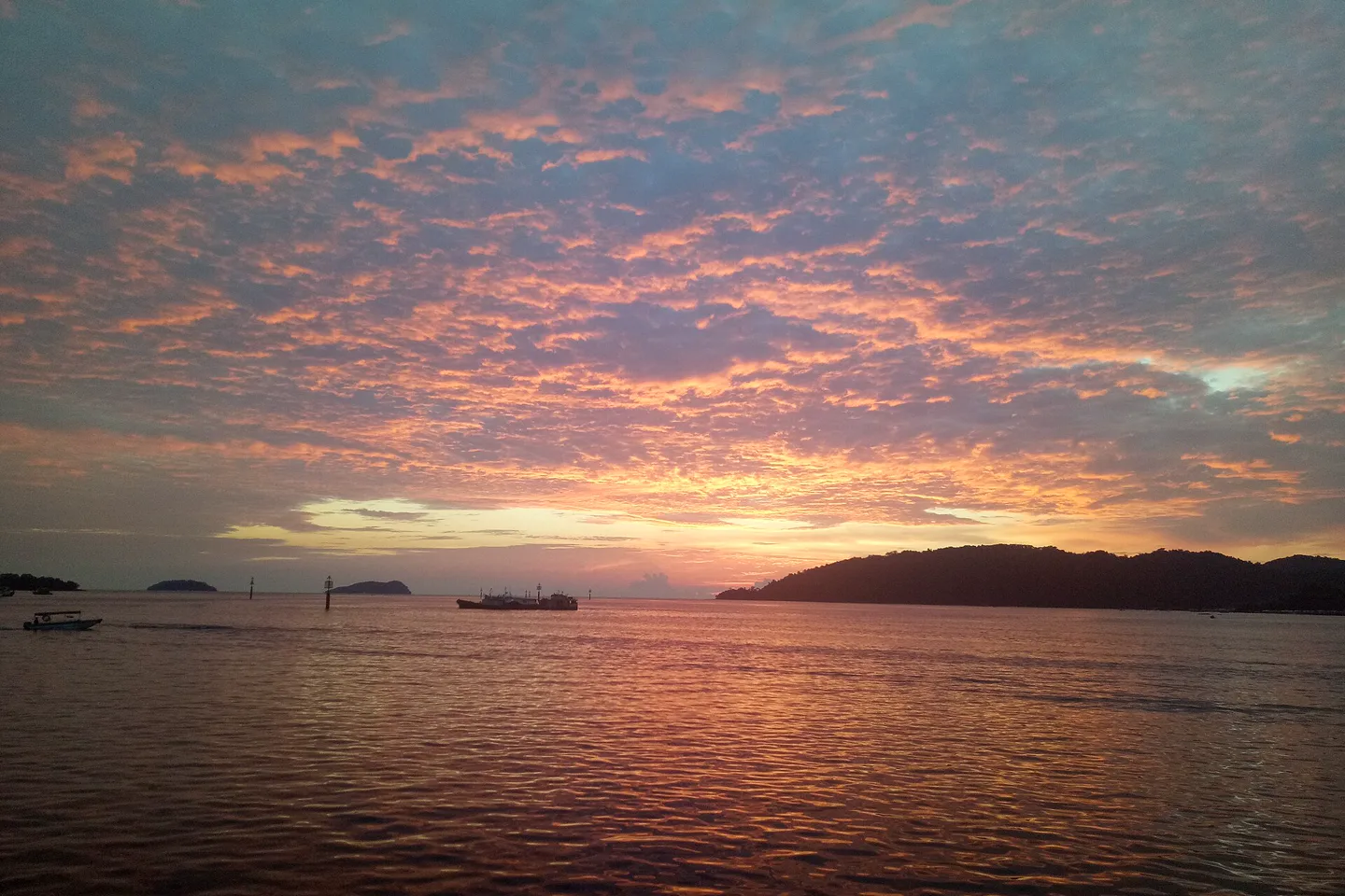 Orange sunset reflected across the sea off Kota Kinabalu