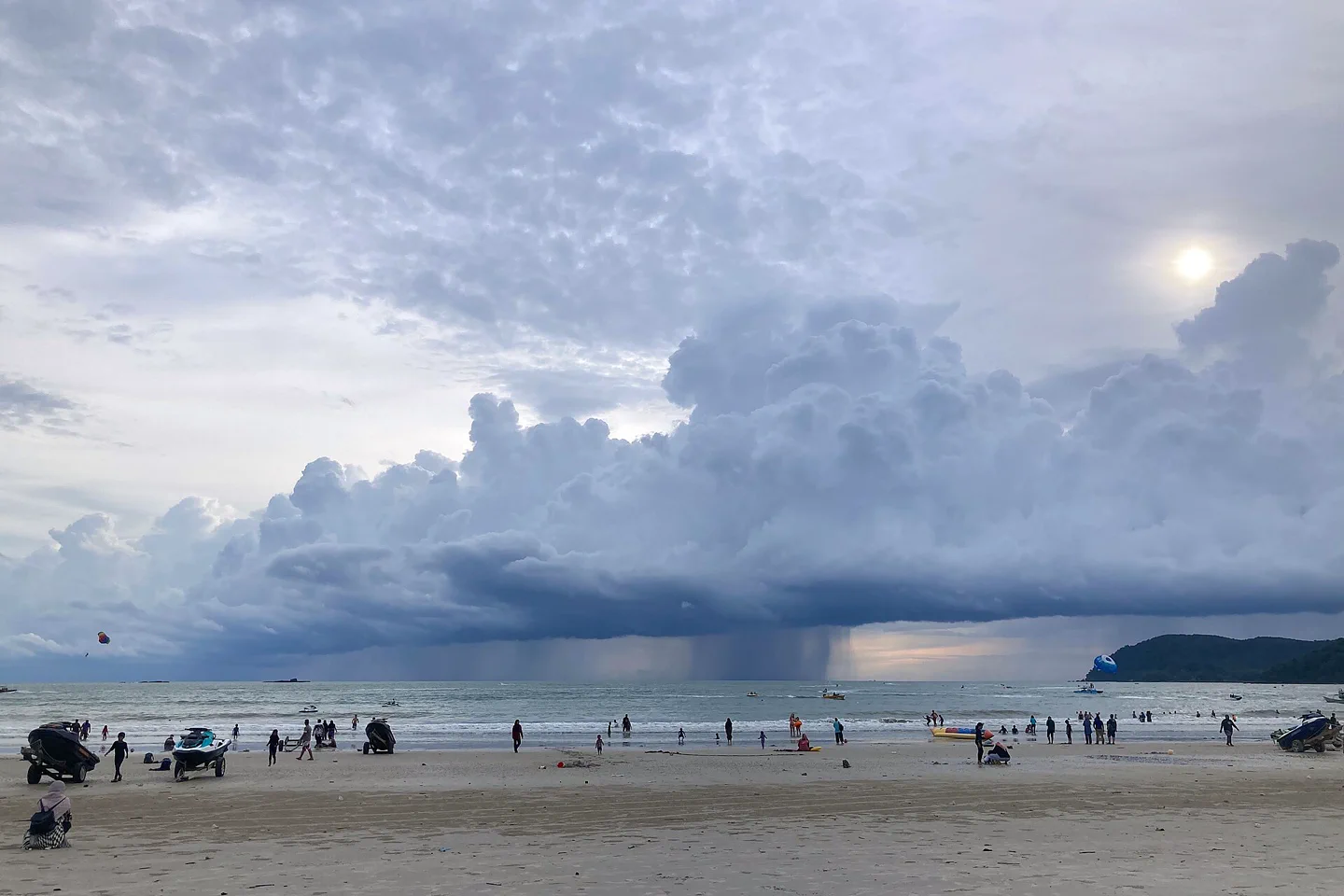Wide Pantai Cenang shoreline beneath a building tropical storm
