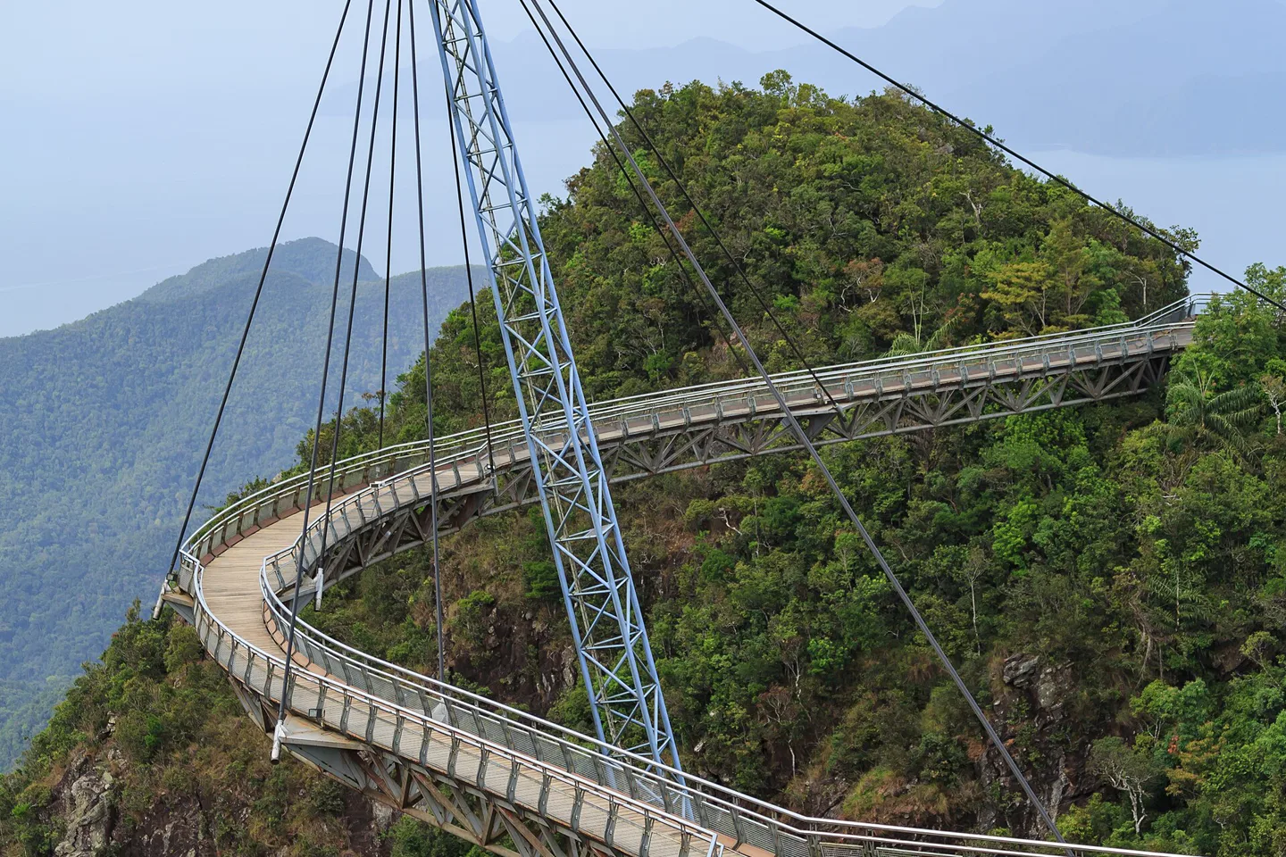 Curving Langkawi Sky Bridge suspended above forested mountain slopes