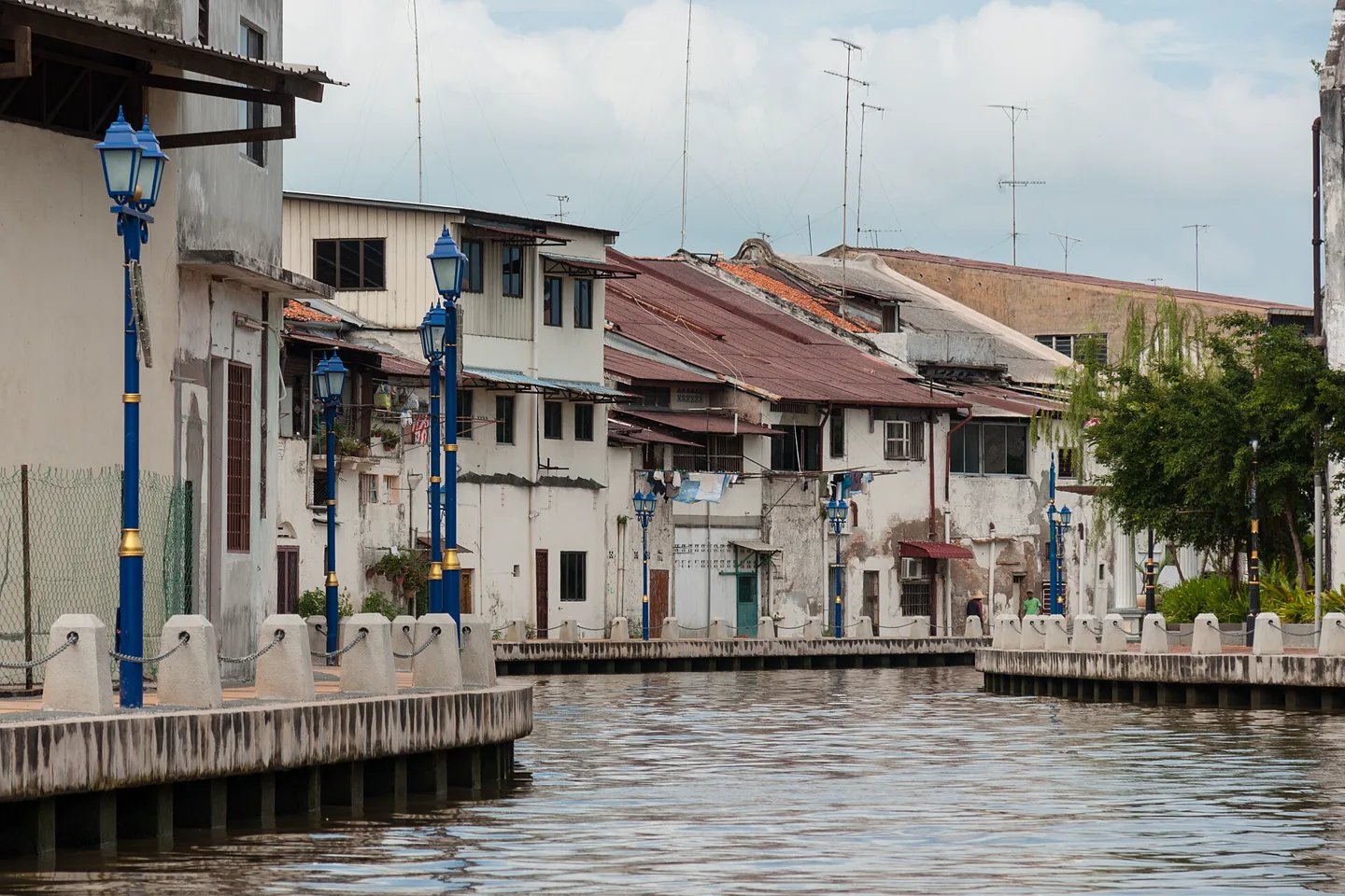 Historic houses and blue lamps lining the Melaka River