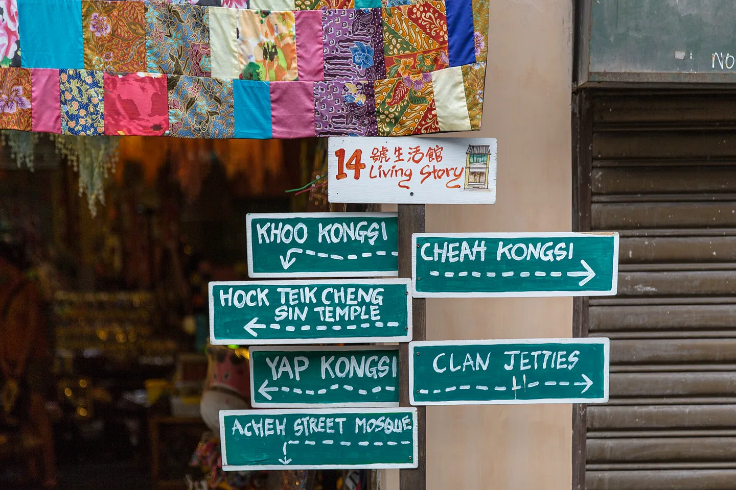 Hand-painted direction signs and colorful textile panels in George Town