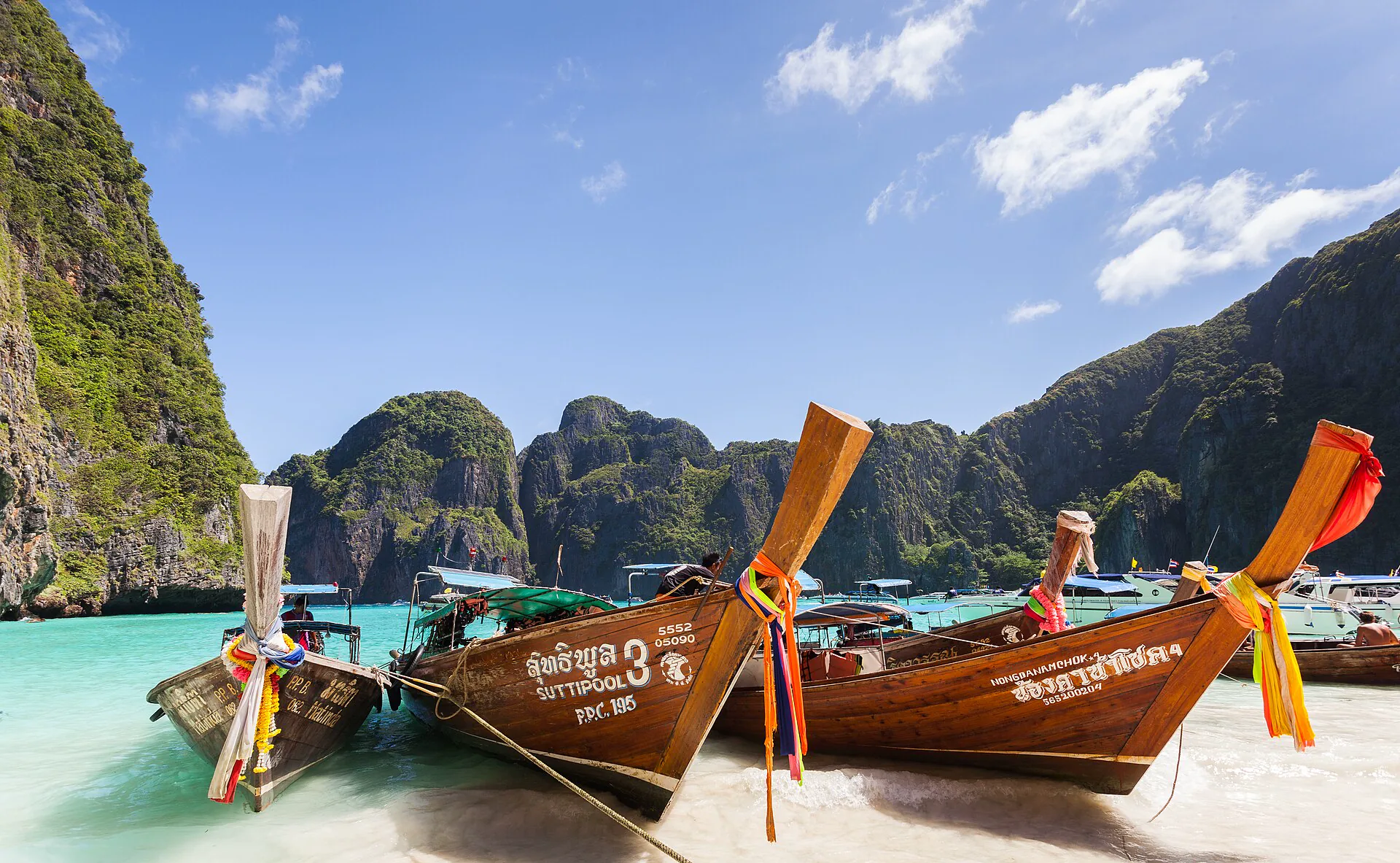 Long-tail boats and limestone cliffs at Maya Bay in the Phi Phi islands