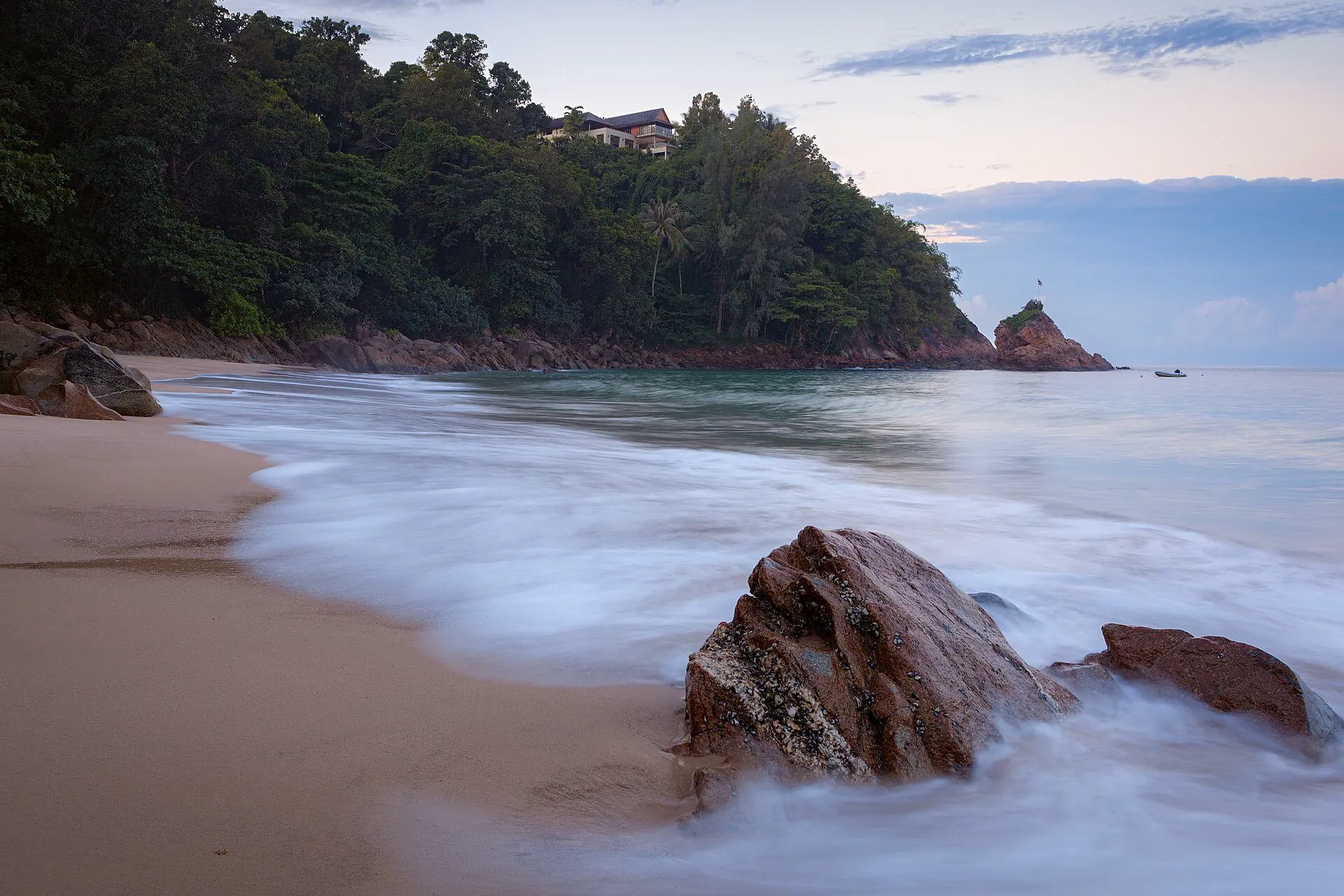 Forested headland and quiet water at Banana Beach in Phuket