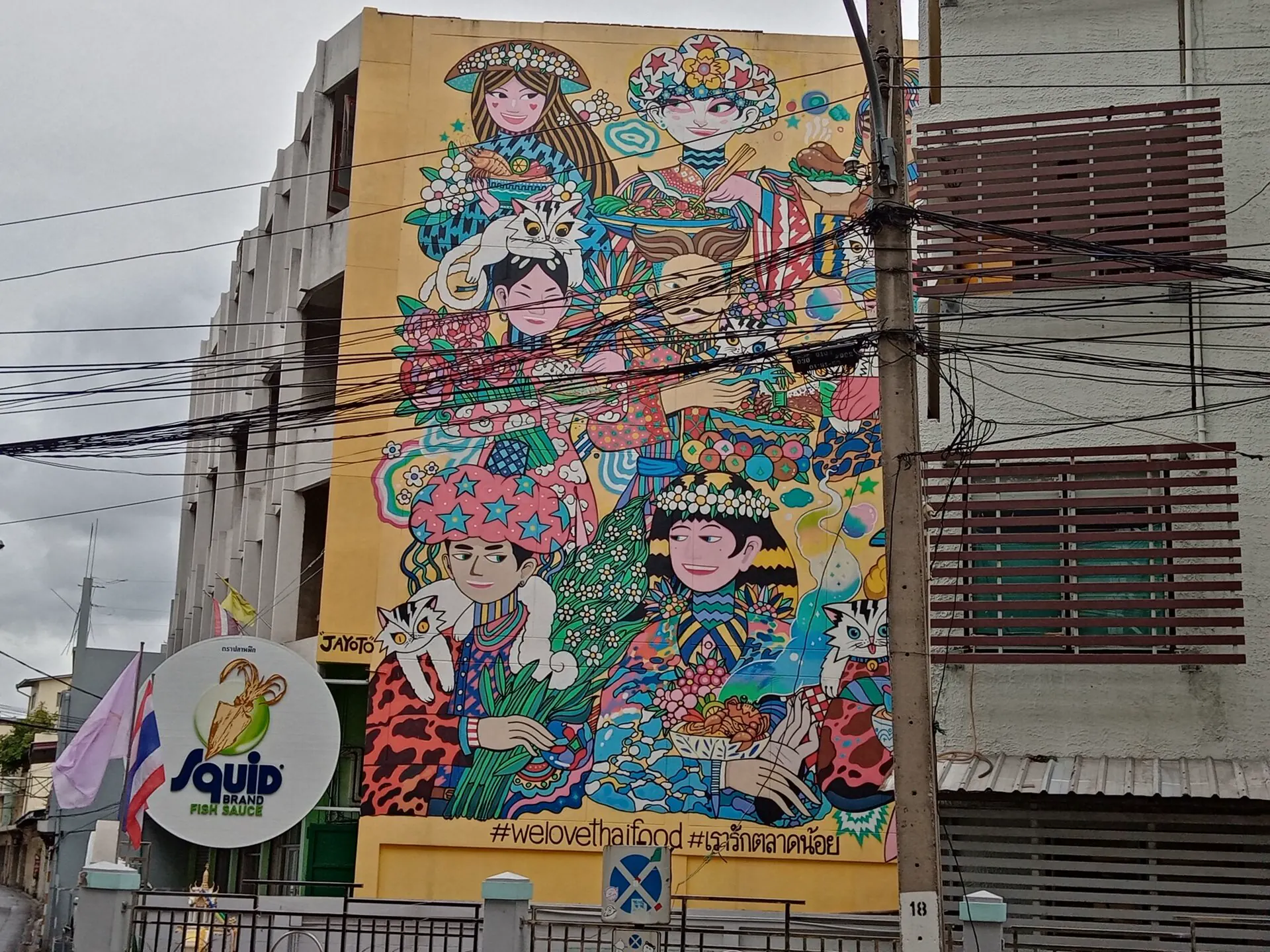 Colorful Thai food mural above the street in Talat Noi