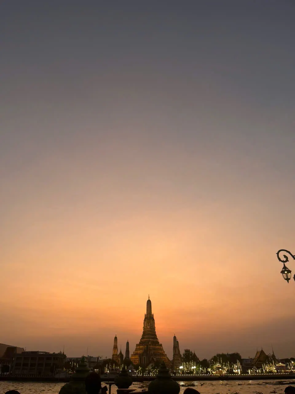 Wat Arun silhouetted beneath a warm Bangkok sunset